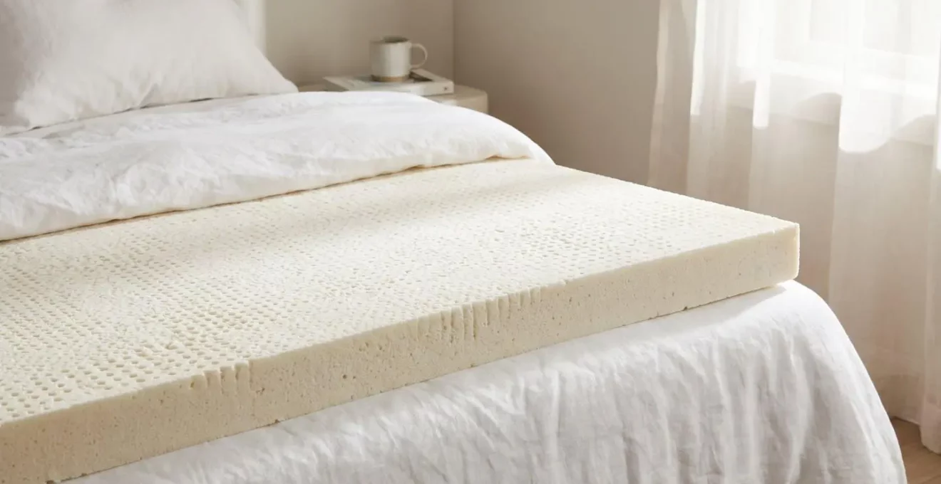 Surmatelas à mémoire de forme posé sur un lit, vue en gros plan sur la mousse viscoélastique
